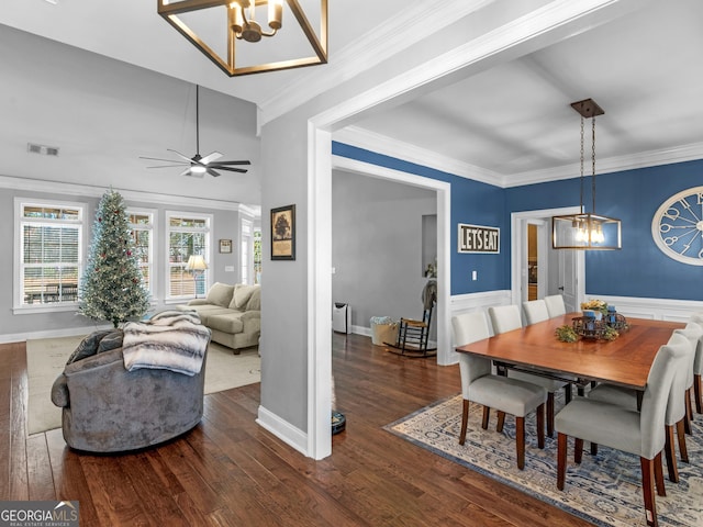 dining space featuring ceiling fan with notable chandelier, crown molding, and dark wood-type flooring