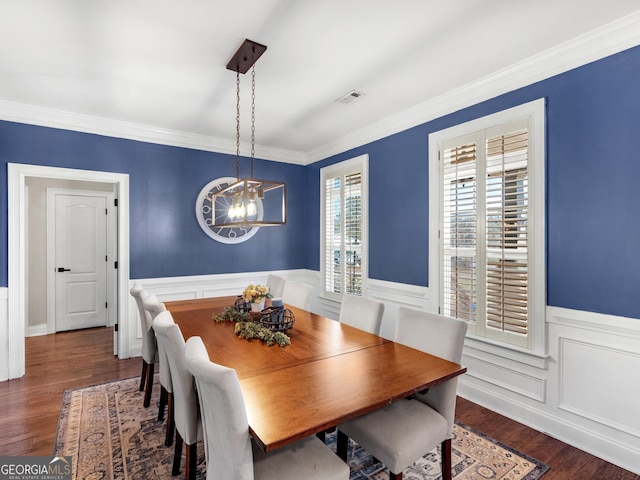 dining room featuring crown molding, dark hardwood / wood-style flooring, and an inviting chandelier