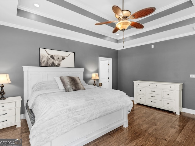 bedroom with dark hardwood / wood-style flooring, a raised ceiling, ceiling fan, and crown molding