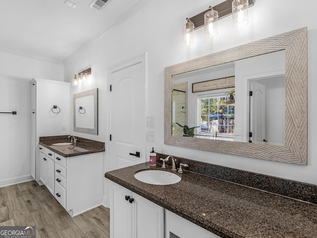 bathroom featuring wood-type flooring, vanity, and ornamental molding