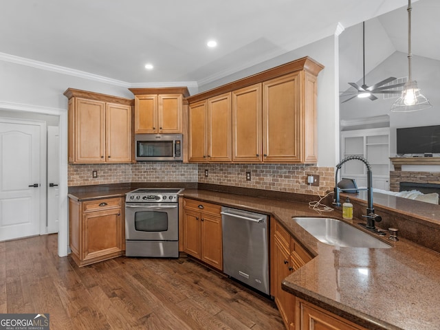 kitchen with decorative backsplash, appliances with stainless steel finishes, ceiling fan, sink, and pendant lighting