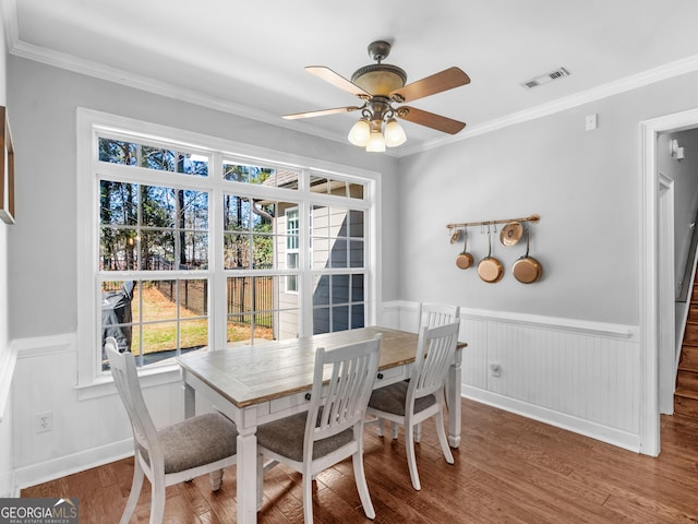 dining room with hardwood / wood-style floors, ceiling fan, and crown molding