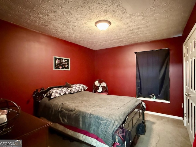 bedroom featuring a textured ceiling and carpet floors