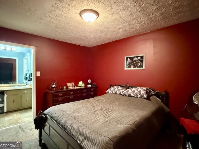 bedroom with connected bathroom, sink, and a textured ceiling