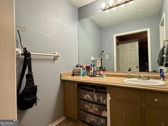 bathroom featuring tile patterned flooring, vanity, and a textured ceiling