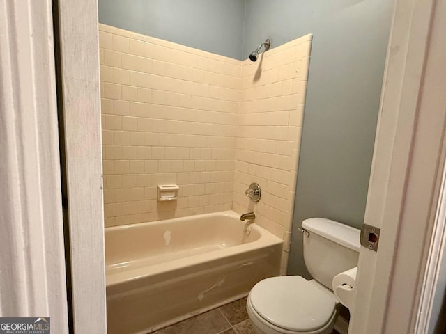 bathroom with tile patterned floors, tiled shower / bath combo, and toilet