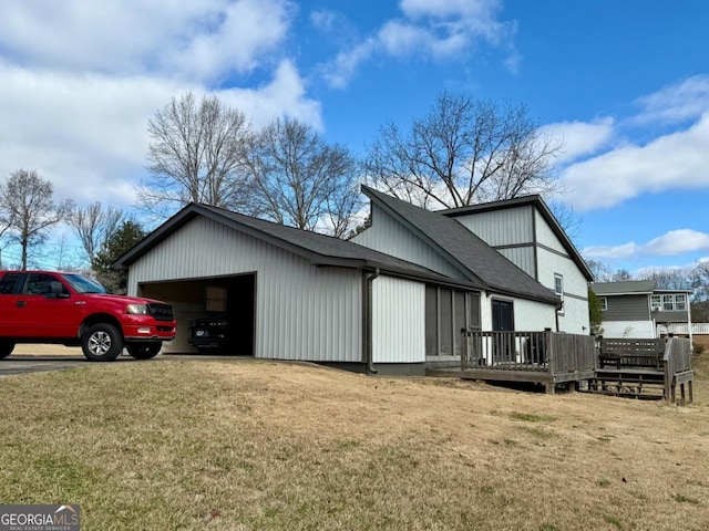 view of property exterior with a garage, a yard, and a wooden deck