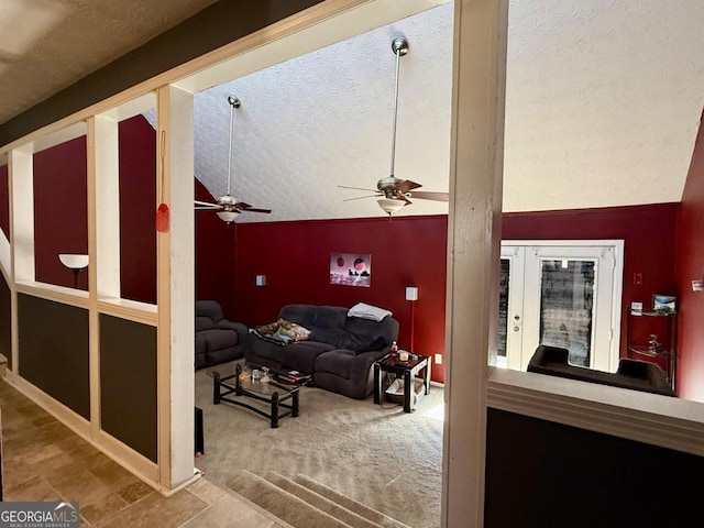 carpeted living room featuring a textured ceiling, vaulted ceiling, and ceiling fan