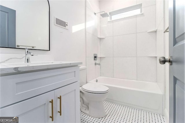 full bathroom with toilet, vanity, and tiled shower / bath