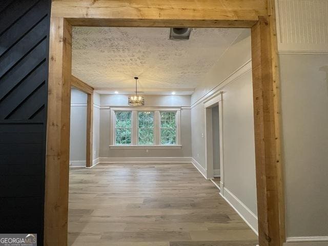 hallway with hardwood / wood-style flooring and a textured ceiling