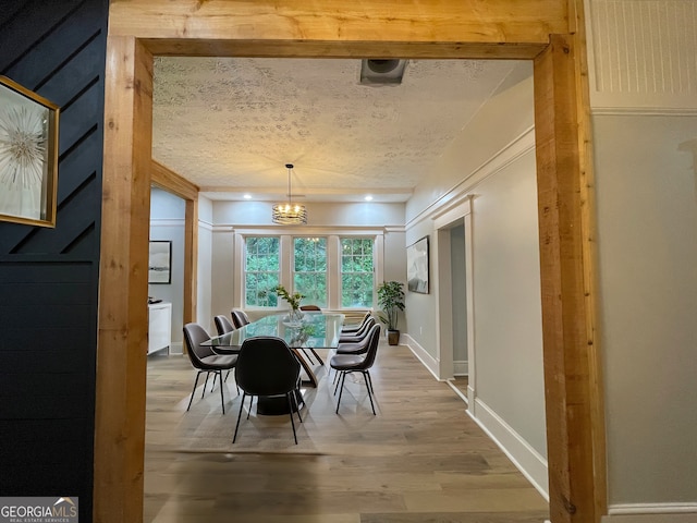 dining area with a chandelier, hardwood / wood-style floors, and a textured ceiling