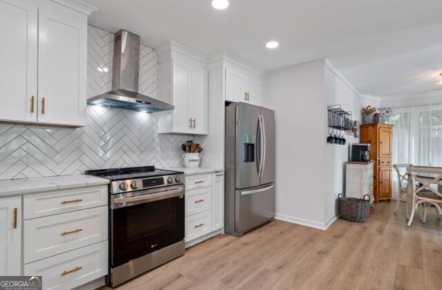 kitchen featuring white cabinetry, wall chimney range hood, stainless steel appliances, and tasteful backsplash