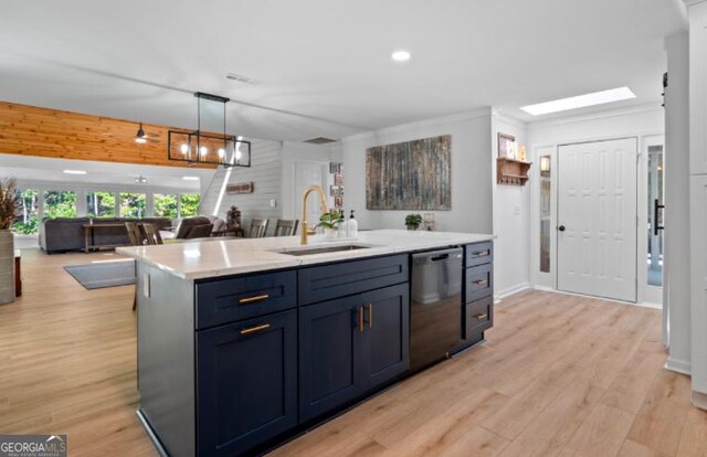 kitchen with dishwasher, sink, an island with sink, decorative light fixtures, and light wood-type flooring