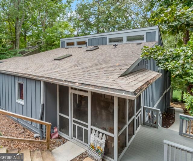 back of house with a sunroom and a deck