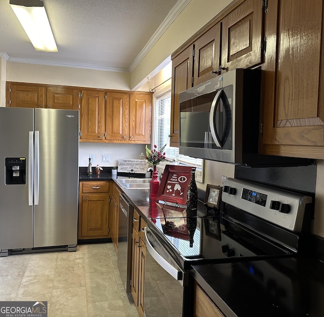 kitchen featuring appliances with stainless steel finishes, ornamental molding, and sink