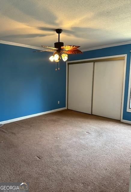 unfurnished bedroom with ceiling fan, crown molding, and carpet floors