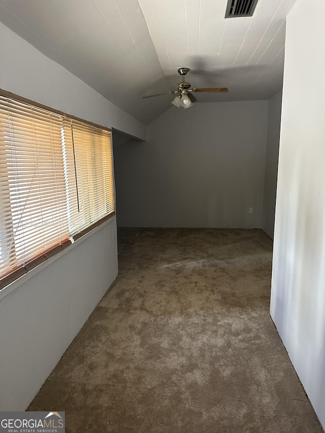 carpeted spare room featuring ceiling fan and lofted ceiling