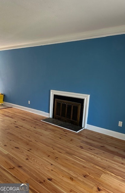 interior space with wood-type flooring and crown molding