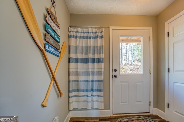 doorway featuring wood-type flooring and a textured ceiling