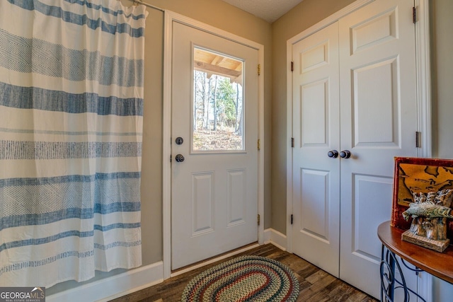 entryway with dark hardwood / wood-style flooring