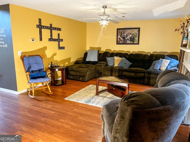 living room with wood-type flooring, a textured ceiling, and ceiling fan