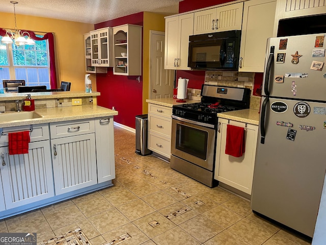 kitchen with sink, hanging light fixtures, appliances with stainless steel finishes, a notable chandelier, and white cabinetry