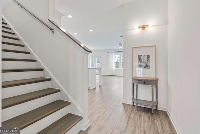 staircase featuring hardwood / wood-style flooring and ceiling fan