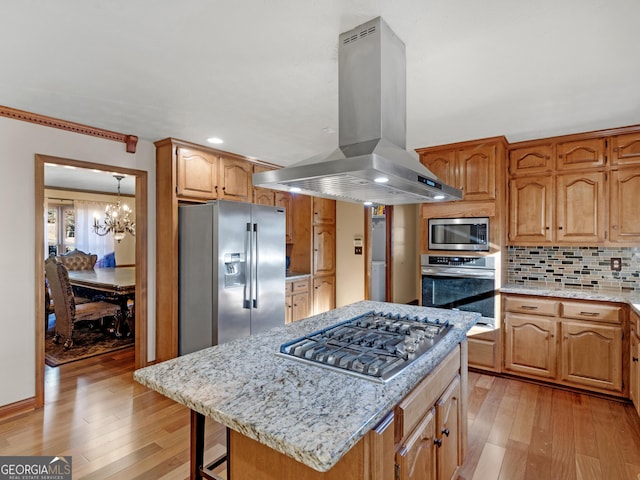 kitchen with a center island, stainless steel appliances, a notable chandelier, backsplash, and island range hood