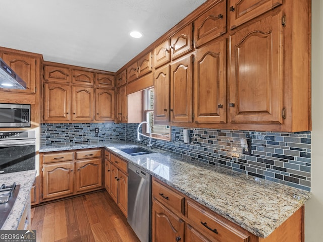 kitchen with decorative backsplash, light stone countertops, dark hardwood / wood-style floors, and appliances with stainless steel finishes