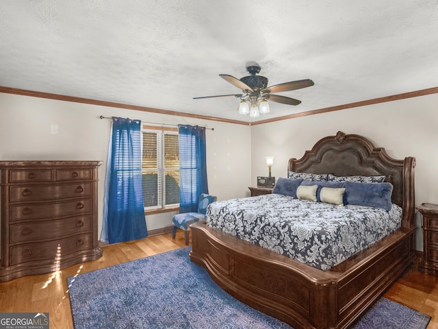 bedroom featuring ceiling fan, light hardwood / wood-style floors, and crown molding