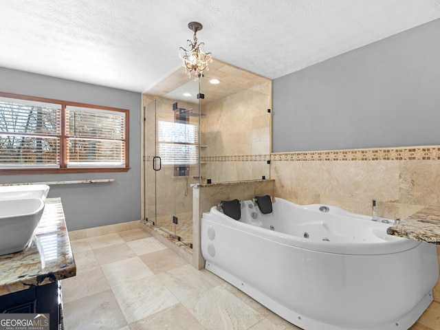 bathroom featuring plenty of natural light, vanity, a textured ceiling, and a notable chandelier