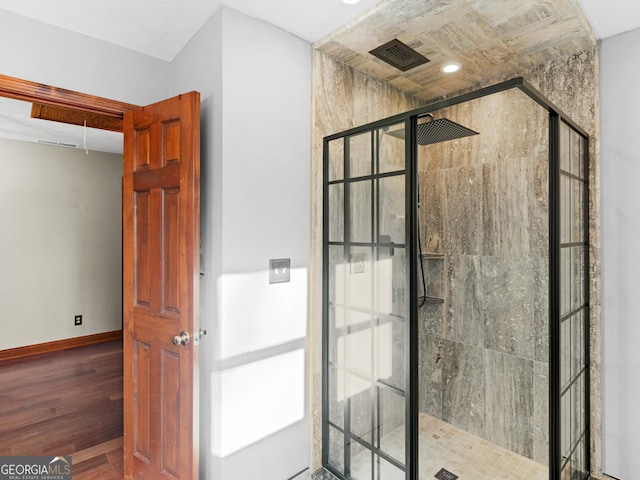 bathroom featuring wood-type flooring and tiled shower