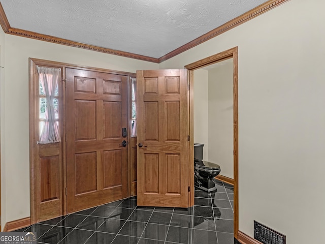 tiled foyer featuring a textured ceiling and crown molding