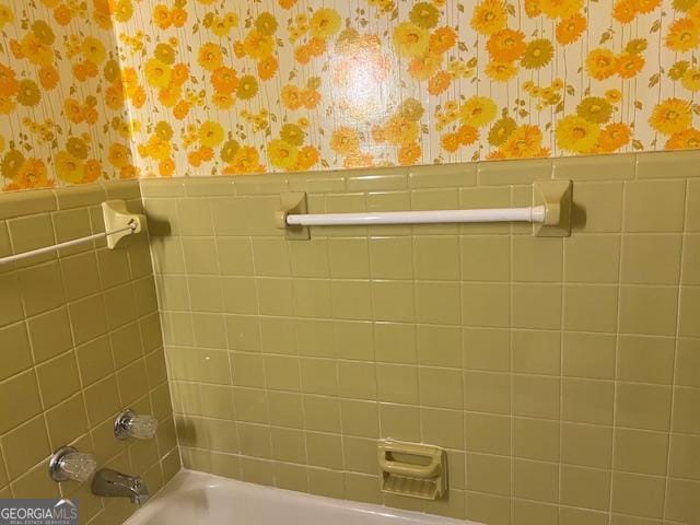 bathroom featuring a bathing tub and tile walls