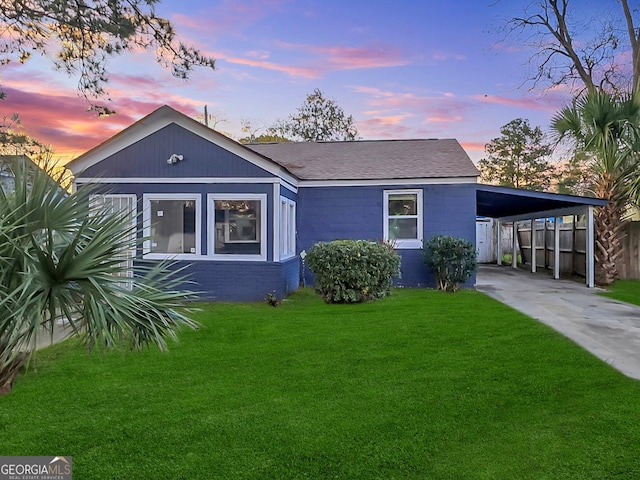 view of front of property featuring a carport and a yard