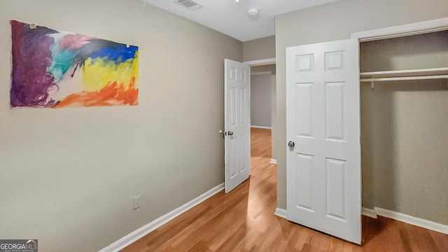 bedroom with hardwood / wood-style flooring and a closet