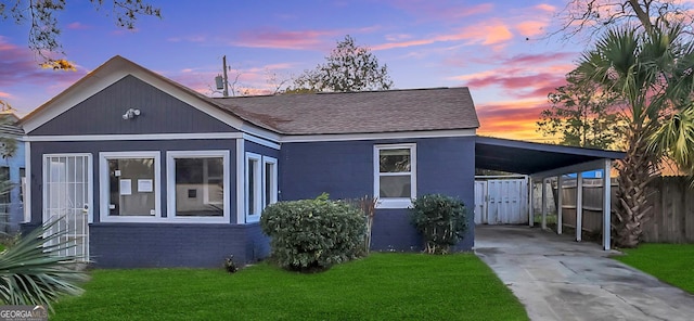 bungalow-style home featuring a yard and a carport