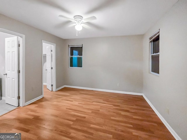 unfurnished bedroom with ceiling fan, light wood-type flooring, and a spacious closet