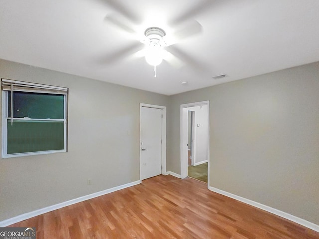 empty room with ceiling fan and light wood-type flooring