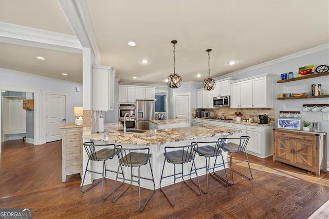 kitchen featuring white cabinets, a kitchen breakfast bar, kitchen peninsula, and appliances with stainless steel finishes