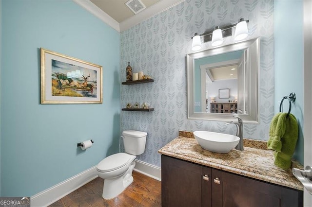 bathroom with hardwood / wood-style floors, vanity, toilet, and ornamental molding