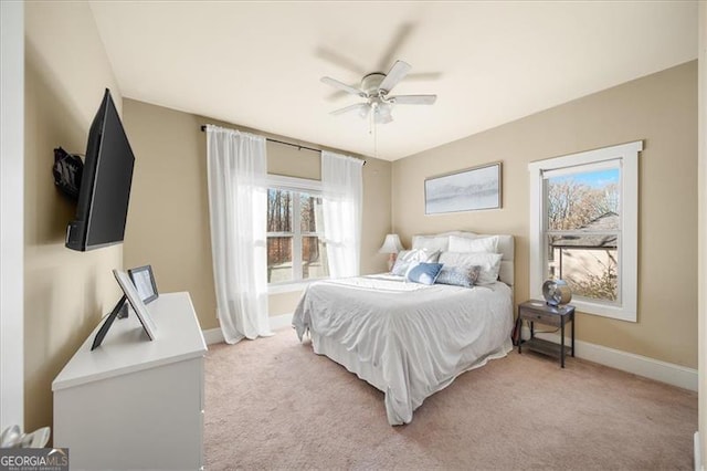 carpeted bedroom with multiple windows and ceiling fan