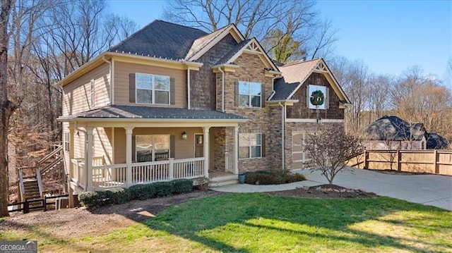 view of front facade featuring a garage, covered porch, and a front lawn