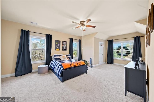 bedroom with ceiling fan, light colored carpet, multiple windows, and vaulted ceiling