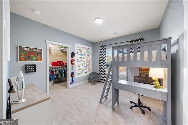 carpeted bedroom featuring a spacious closet and a closet