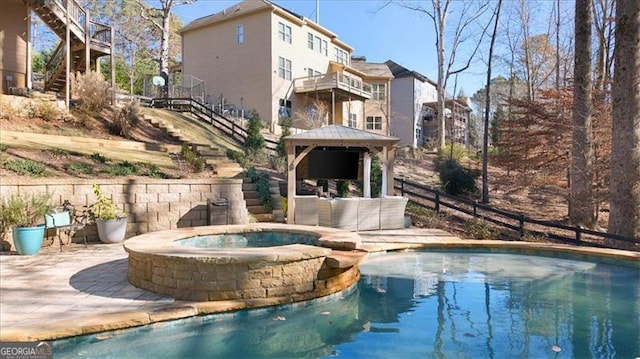 view of swimming pool with a gazebo and an in ground hot tub