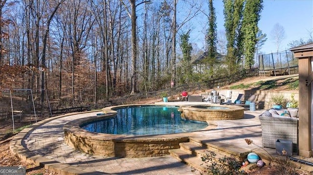 view of pool featuring a patio area and an in ground hot tub