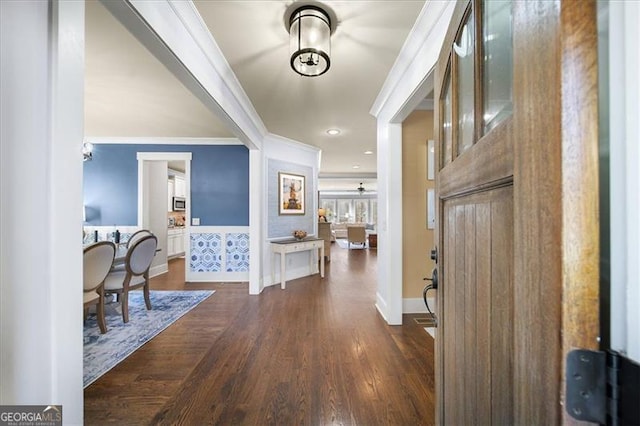 foyer entrance featuring dark wood-type flooring and ornamental molding