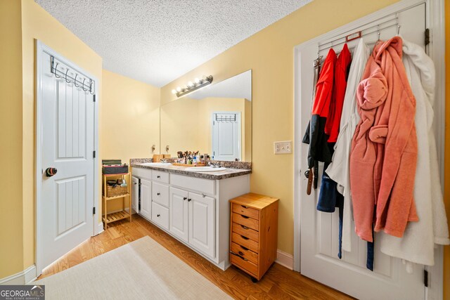 bathroom with vanity, a textured ceiling, and hardwood / wood-style flooring