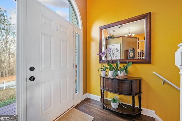 entryway with dark hardwood / wood-style floors and an inviting chandelier